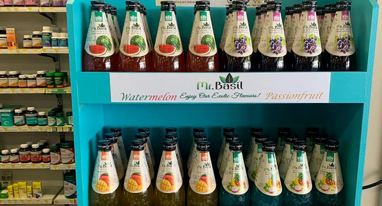 Shelf display in a store featuring 'Mr. Basil' watermelon, passionfruit, and other flavored seed drinks, with a teal branding header.