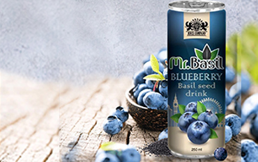 A can of Mr. Basil Blueberry flavored basil seed drink with fresh blueberries and a bowl of blueberries on a stone textured background.