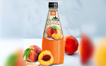 A close-up image of a Mr. Basil peach flavored drink bottle with ripe mangoes in a lush orchard setting.