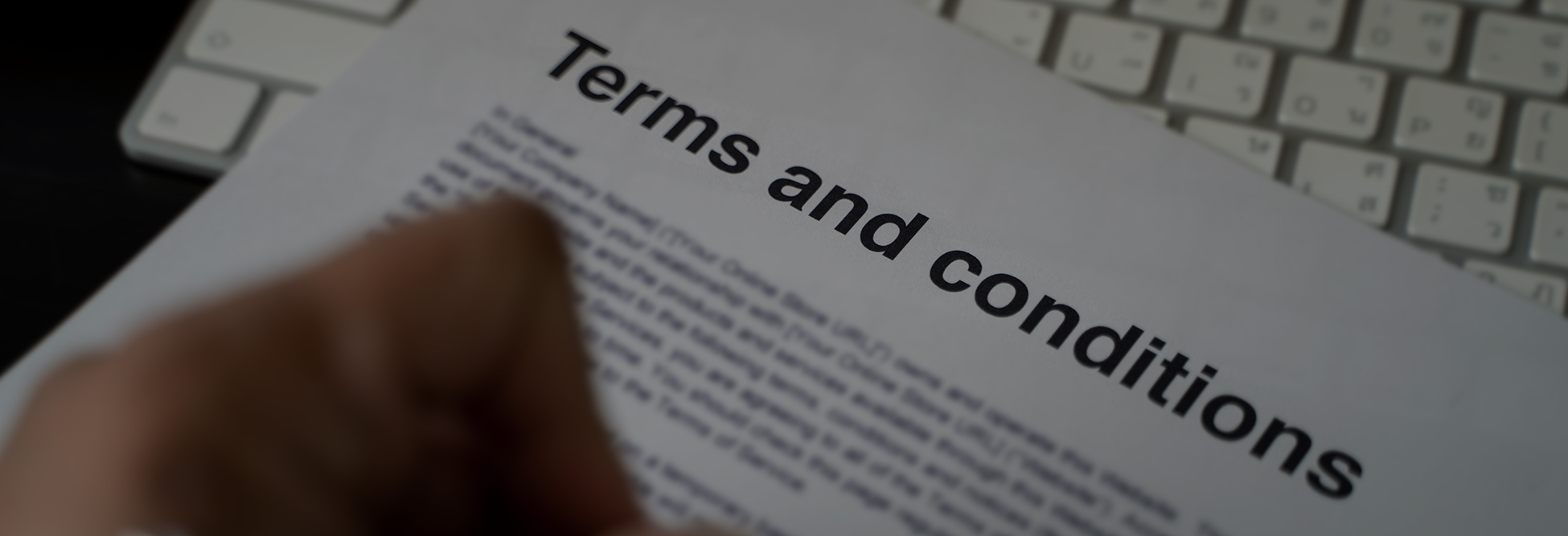 Close-up of a terms and conditions document on a keyboard, highlighting legal agreements and user policies.